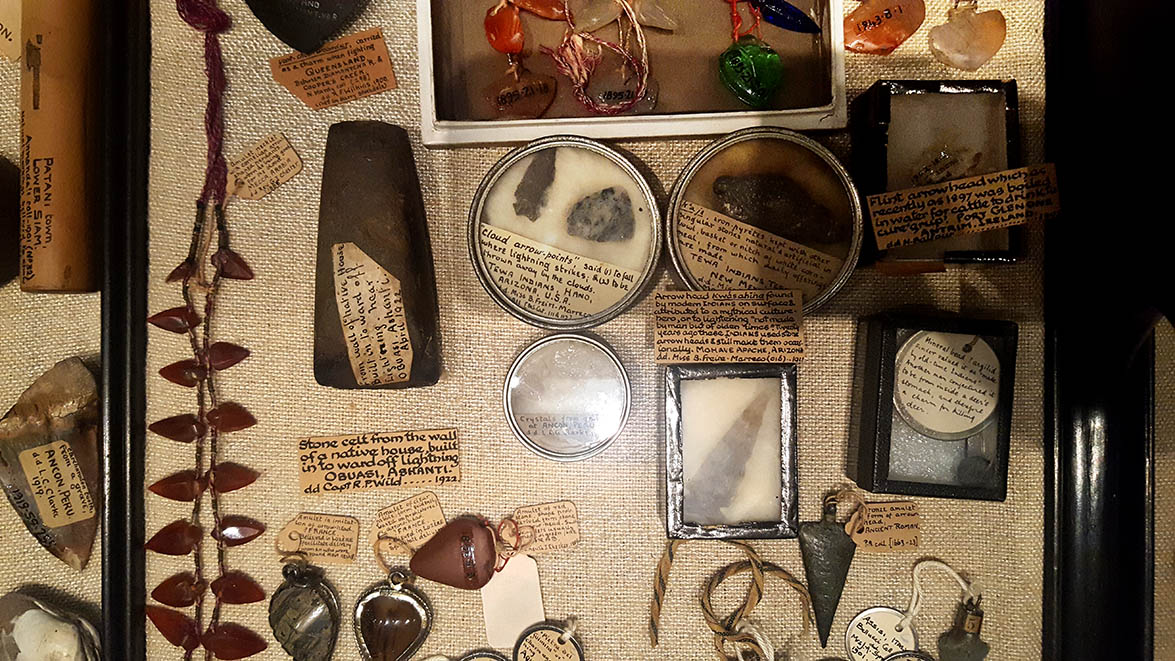Stones and flints with handwritten labels displayed in glass cabinets in The Pitt Rivers Museum